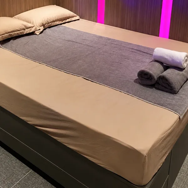 세로형 핑크 조명과 그레이 러너의 더블 침실