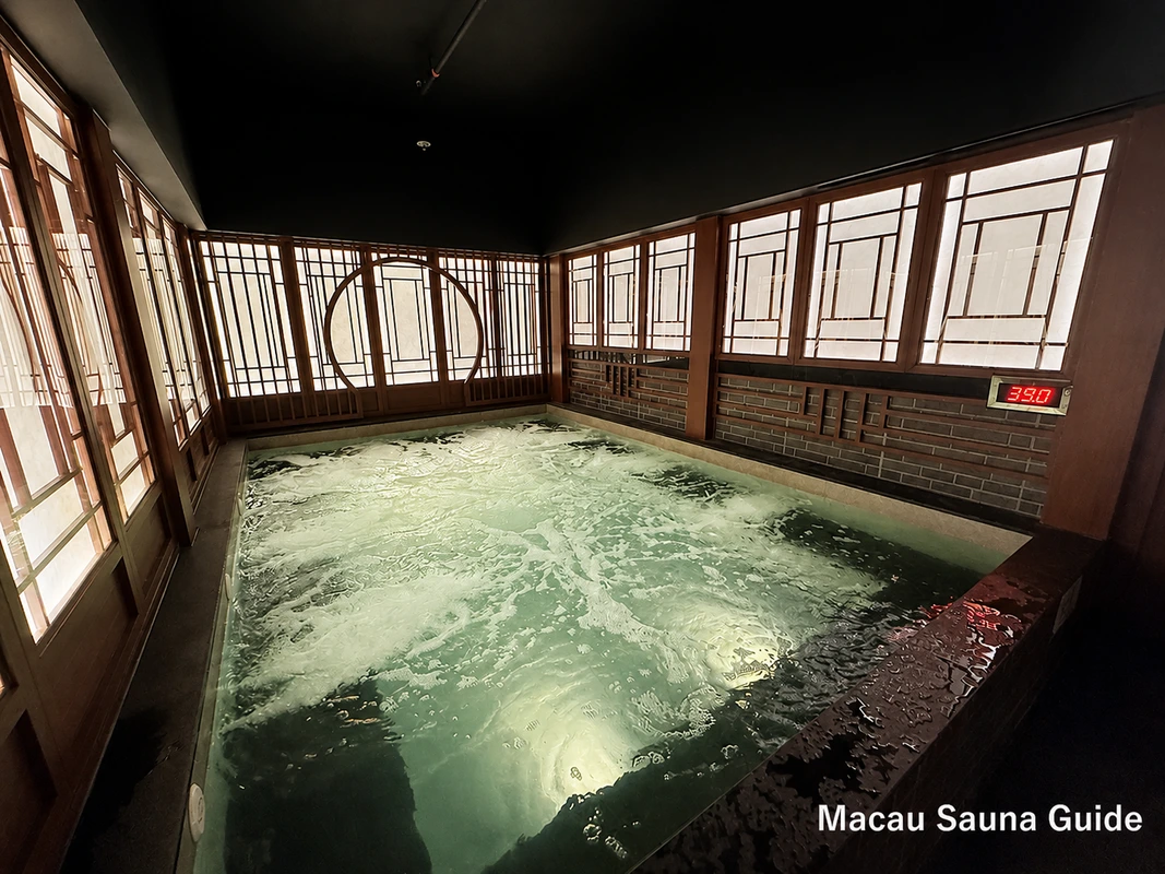 Rectangular bubbling hot pool framed by timber lattice windows at Yu Sauna