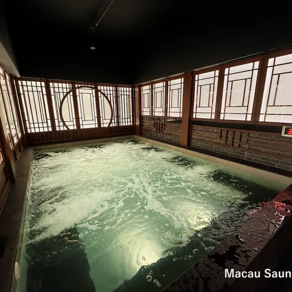 Rectangular bubbling hot pool framed by timber lattice windows at Yu Sauna