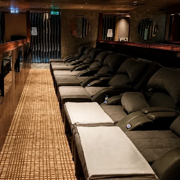 A row of dark recliners reflected in wall mirrors in the Yu Sauna lounge