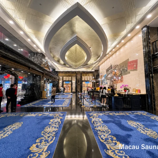 Ornate hotel lobby with blue-and-gold rugs and a reception desk